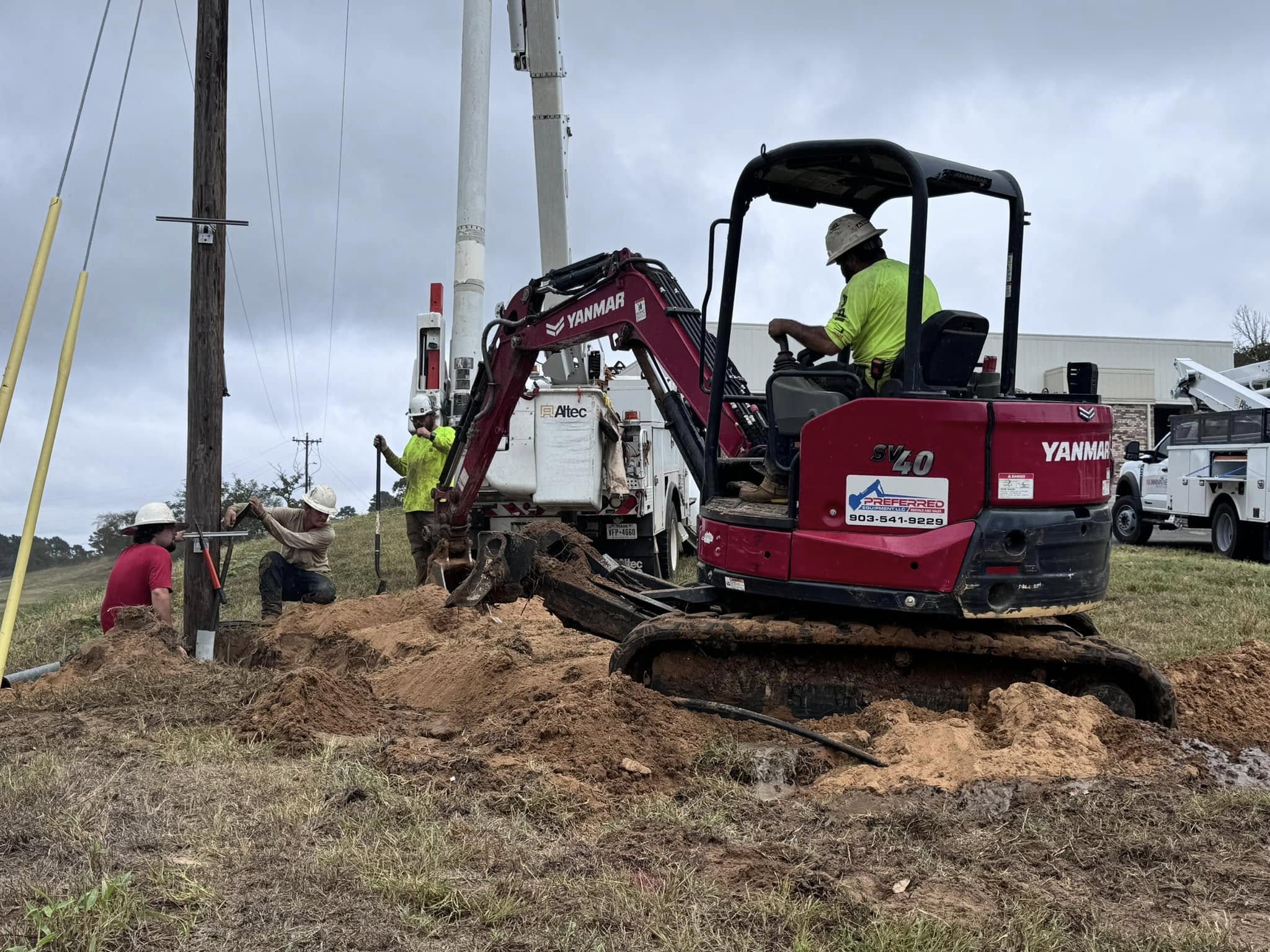 Utility crew working with excavation equipment at a project site